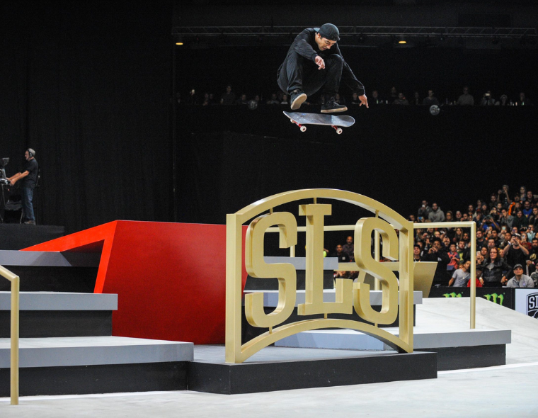 Skatista executando manobra aérea no SLS Super Crown com público e logo oficial da Street League Skateboarding ao fundo