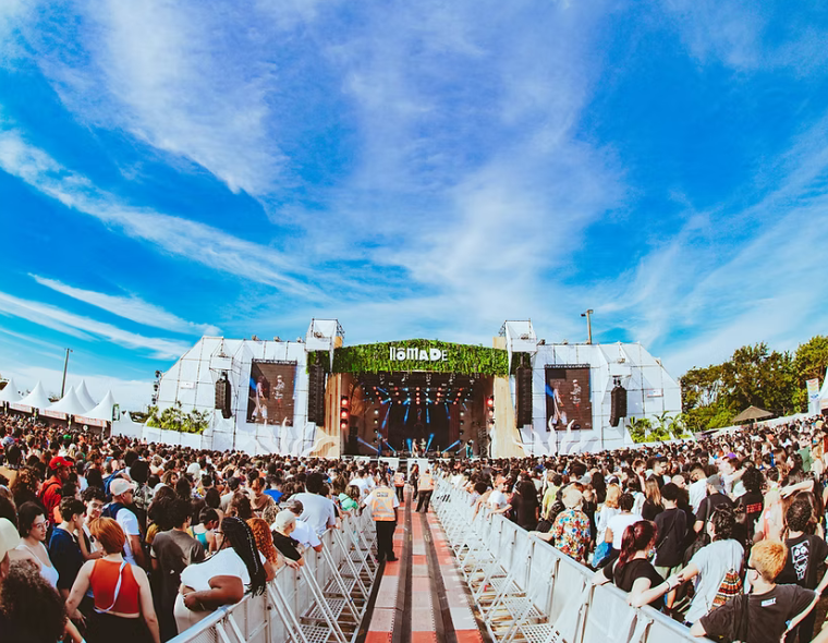 Público animado em frente ao palco principal do Nômade Festival 2026 no Parque Villa-Lobos, São Paulo, sob céu azul com nuvens dispersas
