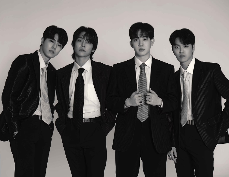 Foto promocional em preto e branco da banda sul-coreana The Rose, que anunciou show no Brasil em 2026. Os quatro integrantes vestem ternos elegantes e olham para a câmera em um fundo neutro.